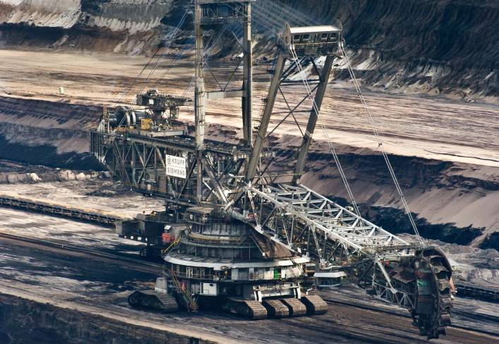 A large crane is in the middle of an open pit.