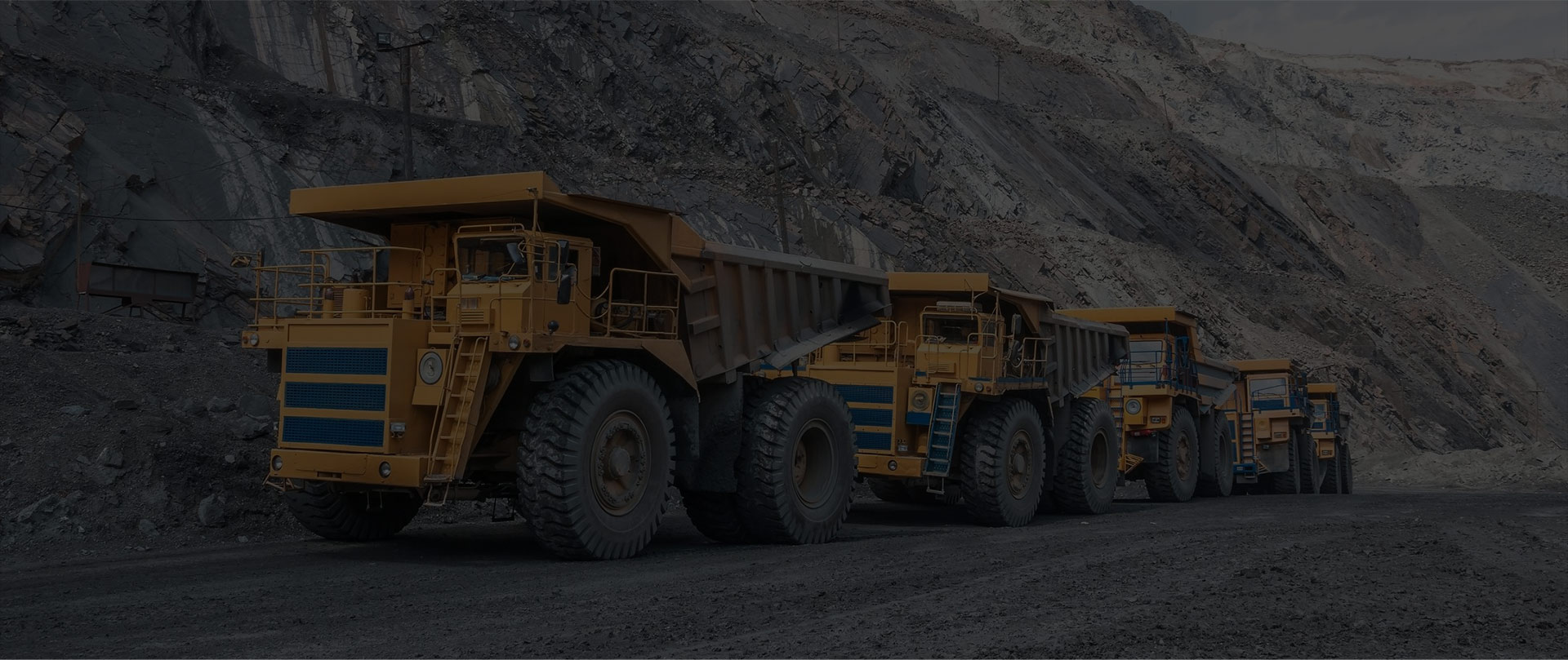 A large dump truck is parked in the middle of a gravel road.