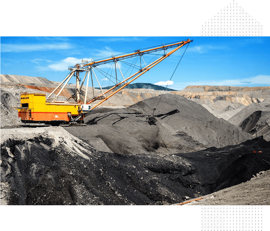 A yellow and black crane on top of a pile of coal.